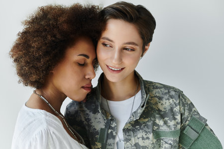 A tender moment between a military soldier and her wife captured in a supportive embrace.の写真素材