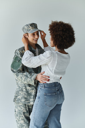 A loving farewell moment between a soldier and her wife in a warm studio atmosphere.の写真素材