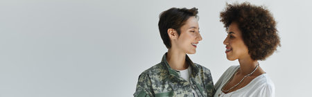 A loving embrace between a soldier in uniform and her wife, capturing a heartfelt moment in a studio.の写真素材