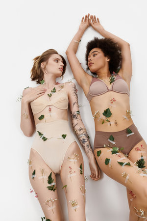 A tender connection shared by two women adorned with flowers and greenery.の写真素材