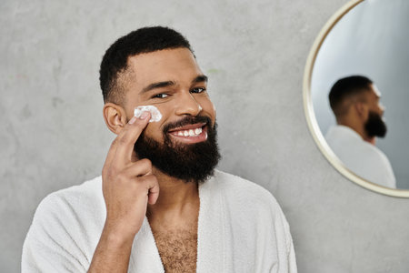 A man applies skincare while smiling in a bright, modern bathroom.の写真素材