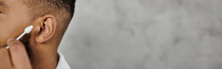 A man focuses on personal grooming in a cozy indoor setting.の写真素材