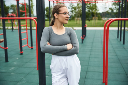 A young woman confidently embraces her outdoor workout, showcasing strength and resilience.