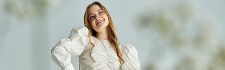 A joyful woman smiles, embracing the beauty of nature with vibrant flowers.の写真素材