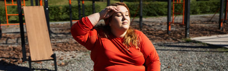 A plus size woman takes a moment to relax after exercising outdoors.