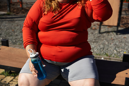 Woman exercises outdoors, embracing fitness and wellness in a vibrant park environment.の写真素材