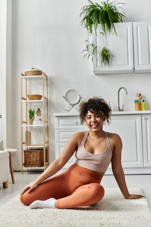 A cheerful woman relaxes comfortably on the floor of her stylish home.の写真素材