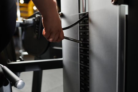 A young plus-size woman confidently engages in weight training, promoting body positivity.