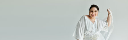 A joyful bride showcases her stunning white gown and earrings, embodying beauty and elegance.の写真素材