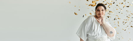 A beautiful young woman in a white gown celebrates her special day, exuding grace amidst shimmering decor.の写真素材