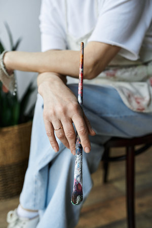 A painter reflects on her artistic journey while holding a brush.の写真素材
