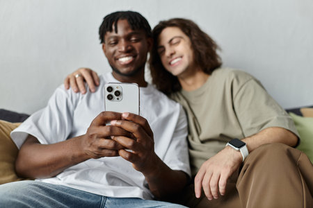 A happy couple relaxes on their couch, sharing a joyful moment and capturing memories together.の写真素材