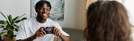 A joyful couple shares laughs while taking pictures in their comfortable living room.