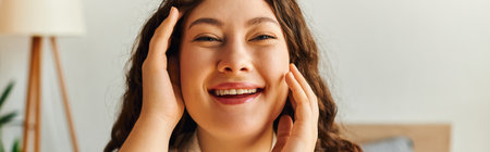 A young plus size woman smiles brightly while relaxing at home, radiating happiness and confidence.