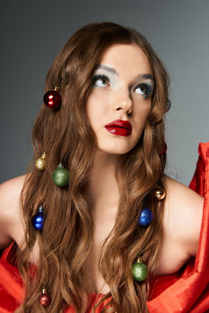 A young woman with long hair decorated by ornaments gazes upward, exuding festive elegance.の写真素材
