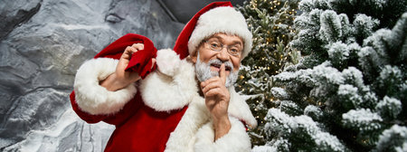 A joyful figure in a red suit shares a secret surrounded by festive greenery and snow.の写真素材