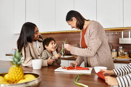A joyful Asian family cooks together in a sleek kitchen, enjoying the festive spirit and creating holiday treats.の写真素材