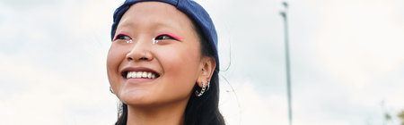 A young woman radiates joy while dressed in a fashionable outfit, embracing outdoor moments.の写真素材