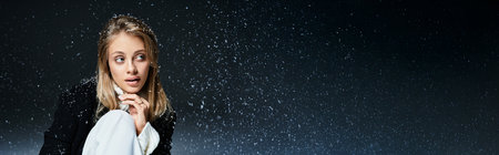 A beautiful young woman gazes thoughtfully as snowflakes dance around her in a winter scene.