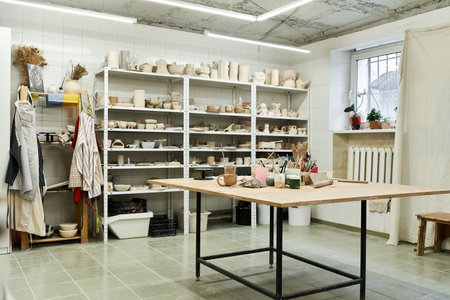 View of pottery studio with table and pots.
