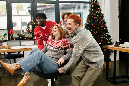 A lively group of young coworkers enjoys Christmas cheer while playing together at work.