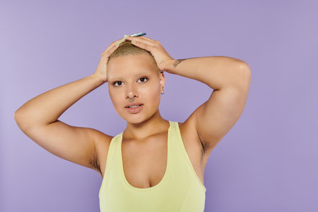 A young bald woman expresses herself in vibrant attire while showcasing her unique beauty.