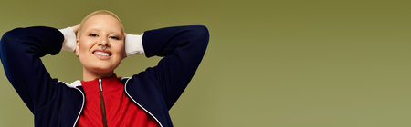 A cheerful young woman showcases her unique style in bright clothing while smiling confidently.の写真素材