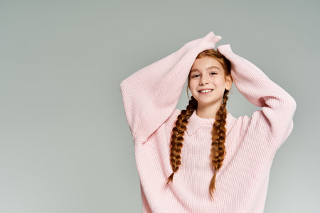 A cheerful young girl, dressed in soft winter clothing, enjoys a moment of playful joy indoors.