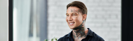 Young man with tattoos working in his office.の写真素材