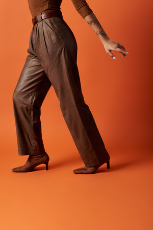 A young woman with stylish outfit poses confidently, showcasing her unique fashion in an artistic studio.の写真素材