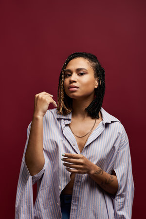 A young woman exudes confidence while posing in a trendy outfit, showcasing her unique braided...