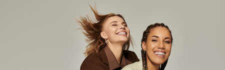 A joyful couple in autumn attire shares laughter, embracing the season together.