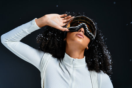A stunning brunette woman models a chic ski suit while striking a fashionable pose indoors.の写真素材
