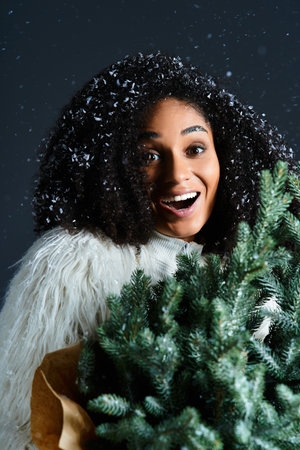 A stunning woman in a white ski suit with a faux fur jacket embraces winter, holding festive...