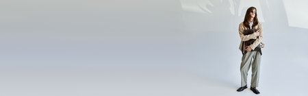 A fashionable young man stands with poise inside, showcasing his unique sense of style.の写真素材