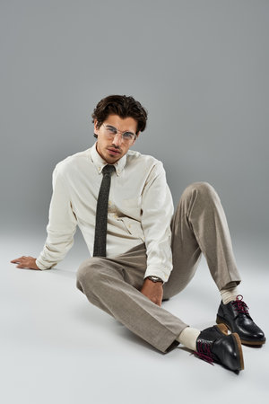 A young man dressed in elegant attire captivates with his confident pose, exuding charm and sophistication.の写真素材