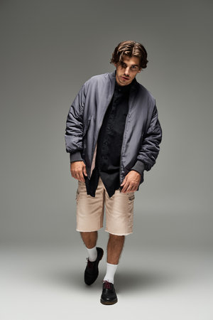 A young man confidently poses in a fashionable autumn outfit, highlighting his unique style and charm.の写真素材