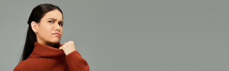 A young woman displays a striking emotional expression while dressed fashionably.の写真素材