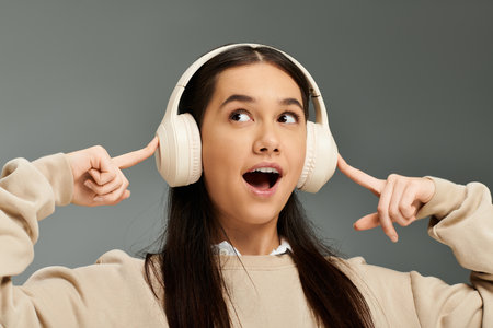 A young woman captures the joy of music while wearing fashionable headphones, smiling brightly.