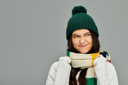 Brightly dressed young woman playfully shows her emotional side while wearing a warm outfit.の写真素材