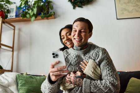 A couple enjoys each others company as they celebrate Christmas together at home.の写真素材