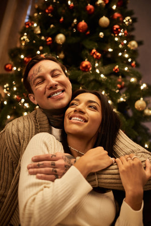 A loving couple enjoys a cozy moment together, surrounded by festive holiday decorations.の写真素材