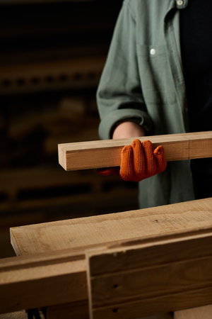 A dedicated female carpenter precisely handles wood, showcasing her craftsmanship in a vibrant...