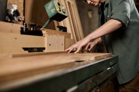 Craftswoman meticulously working with wood in a vibrant workshop, embodying skill and passion for carpentry.の写真素材