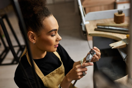 An artisan examines intricate jewels while immersed in her creative workspace.の写真素材