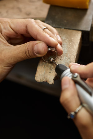 The artisans hands gently shape a stunning jewel, showcasing dedication and craftsmanship.の写真素材