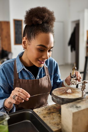 An artisan focuses intently on creating intricate jewelry using skilled hands and toolsの写真素材