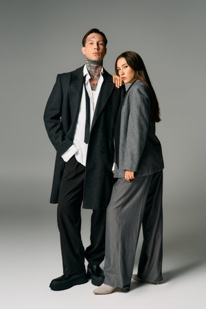 A fashionable duo displays contemporary attire in a sleek studio environment while posing.の写真素材