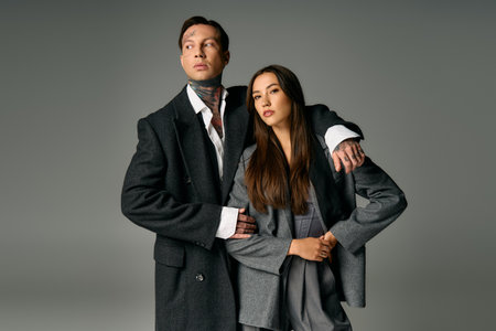 A fashionable young couple poses elegantly, highlighting their trendy attire and captivating style.の写真素材