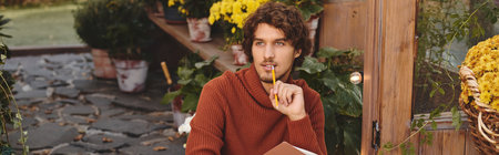 In a lively garden adorned with colorful flowers, a young handsome man sits thoughtfully. With a...